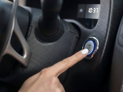 Starter motor repair in Manchester showing the interior of a car and the engine start-stop button being activated following a mobile auto electrical fix.