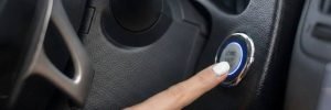 Starter motor repair in Manchester showing the interior of a car and the engine start-stop button being activated following a mobile auto electrical fix.