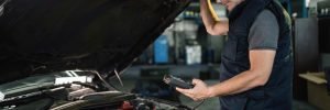 VAG specialist services Manchester showing an expert technician looking under the bonnet of a Volkswagen Group vehicle to perform a detailed engine inspection.